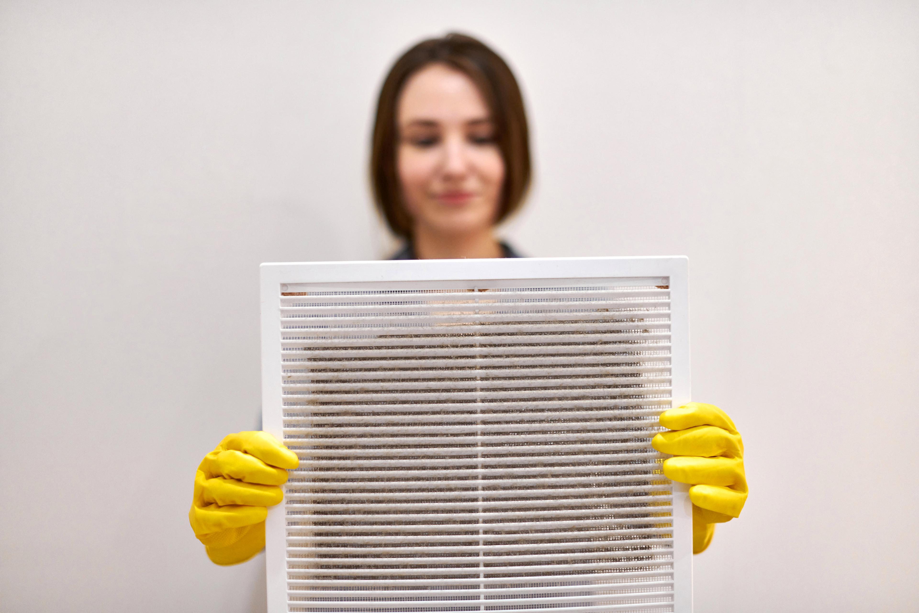 A dusty air filter being held up
